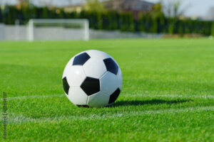 balon de futbol clasico sobre cesped verde