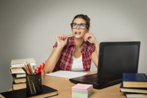 estudiante con libros y computadora en escritorio