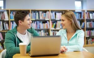 Cómo Hacer un Reclamo de Becas Progresar Paso a Paso 1 estudiante feliz usando computadora en biblioteca