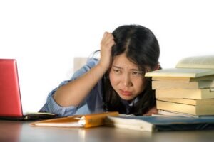 Qué pasa si no me presento a un final en la universidad 5 estudiante preocupado con libros y computadora