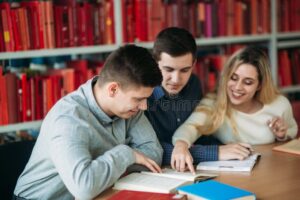 jovenes estudiando con libros y laptop