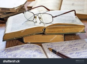 libro abierto con cuaderno y gafas