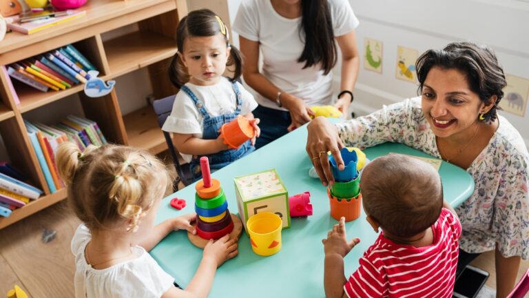 maestra ensenando a ninos pequenos jugando