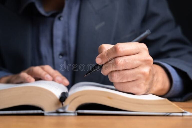 mano subrayando texto en libro abierto