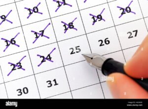 manos con monedas y calendario desenfocado