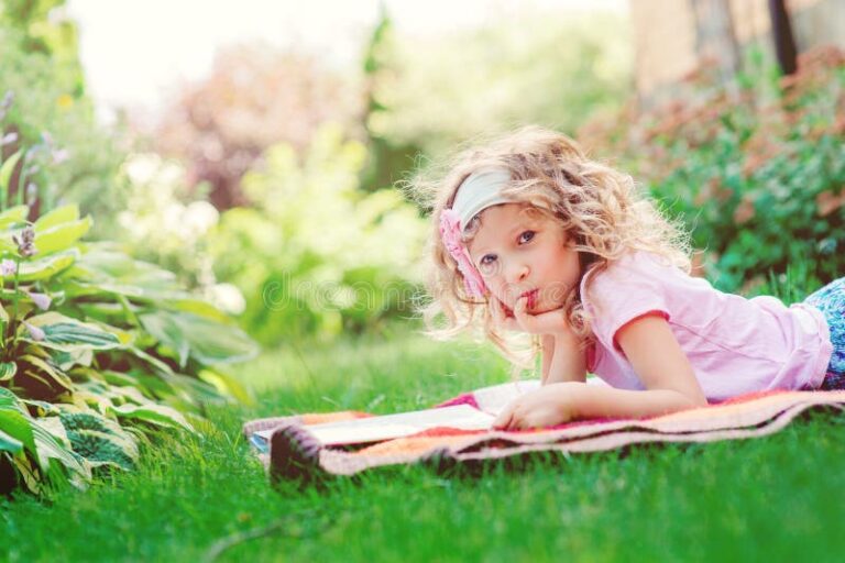 nina leyendo libro en jardin soleado