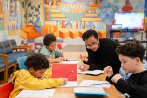 ninos escribiendo poesia en aula colorida