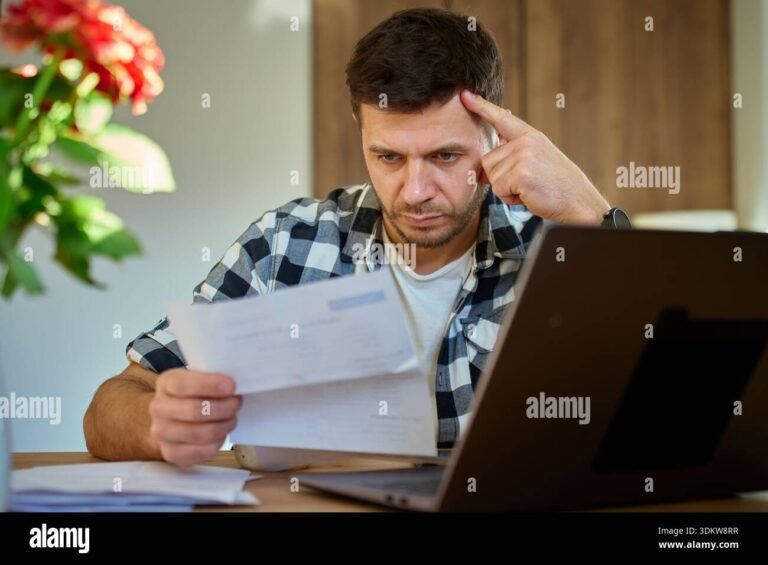 persona preocupada revisando papeles en escritorio