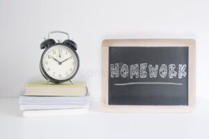 reloj junto a libros y pizarra